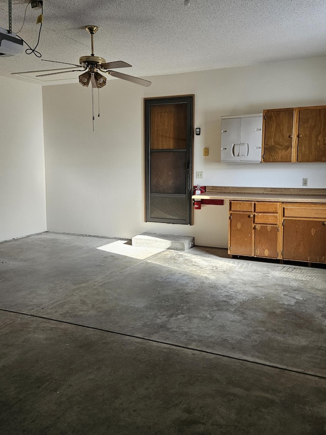 interior space featuring a garage door opener and ceiling fan