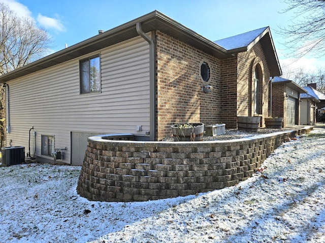 view of snowy exterior with central AC unit