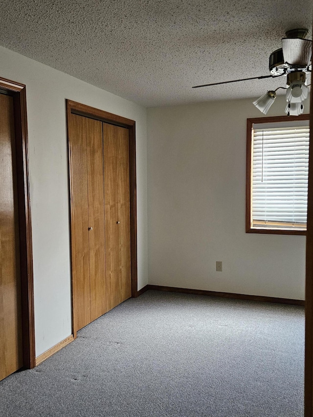 unfurnished bedroom with ceiling fan, a textured ceiling, light carpet, and a closet