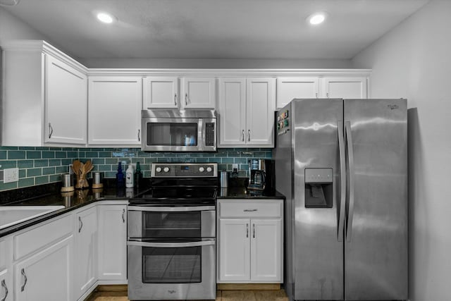 kitchen with appliances with stainless steel finishes, backsplash, and white cabinetry