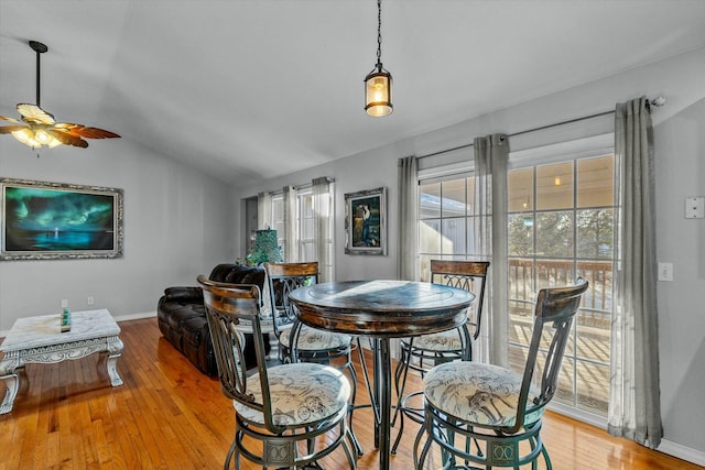 dining space with ceiling fan, vaulted ceiling, and light wood-type flooring