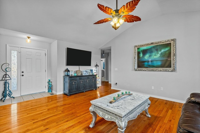 living room featuring ceiling fan, light hardwood / wood-style flooring, and vaulted ceiling