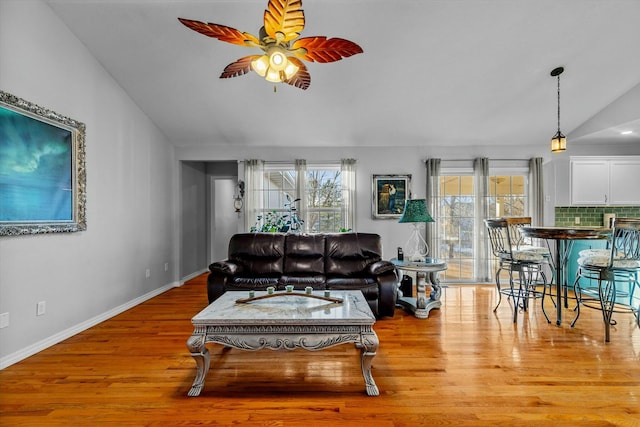 living room featuring lofted ceiling, ceiling fan, and light hardwood / wood-style flooring