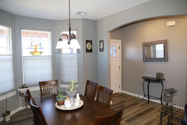 dining space featuring dark hardwood / wood-style floors and an inviting chandelier