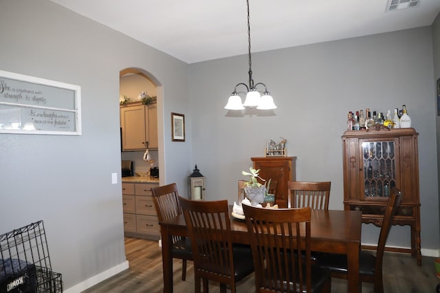 dining space with dark hardwood / wood-style flooring and a notable chandelier