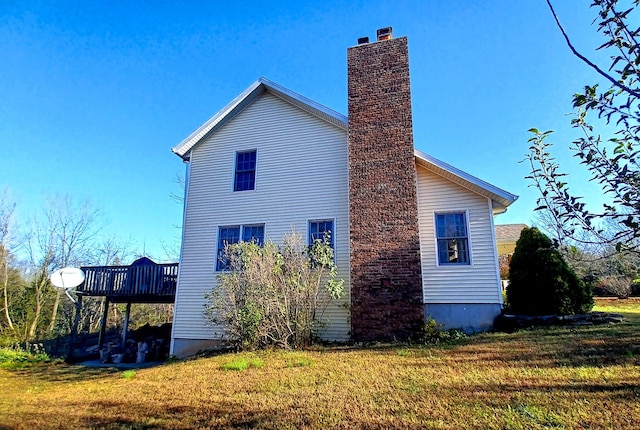 view of side of home featuring a yard and a deck