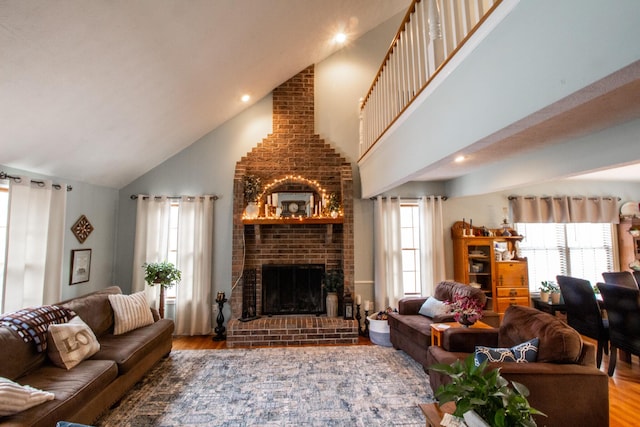 living room featuring hardwood / wood-style flooring, high vaulted ceiling, and a fireplace