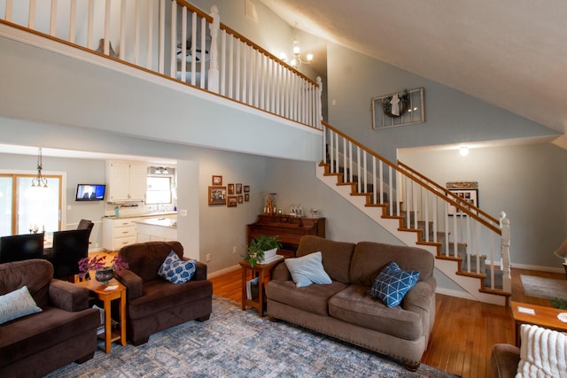 living room featuring an inviting chandelier, hardwood / wood-style floors, and a high ceiling