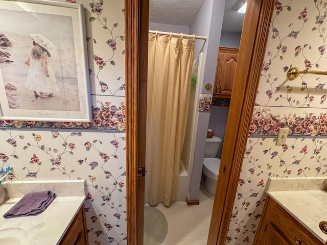 bathroom with vanity, toilet, and a textured ceiling