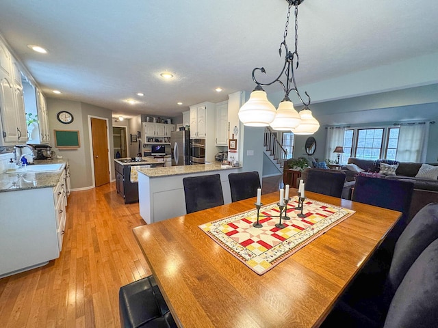 dining area with sink and light wood-type flooring