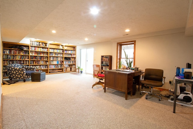 carpeted home office featuring a textured ceiling