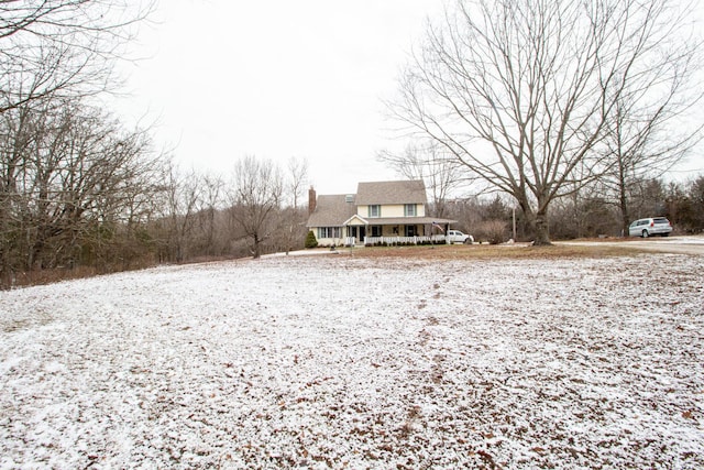 yard covered in snow with covered porch