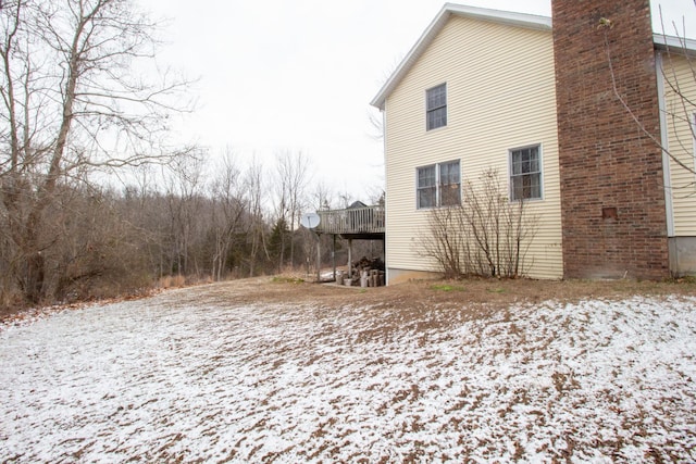 view of snowy exterior with a wooden deck