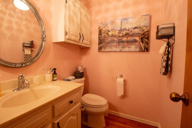 bathroom with hardwood / wood-style flooring, vanity, and toilet