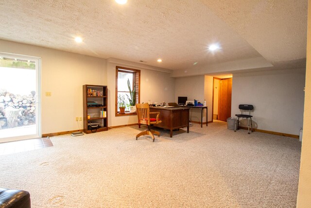 carpeted home office featuring a healthy amount of sunlight and a textured ceiling