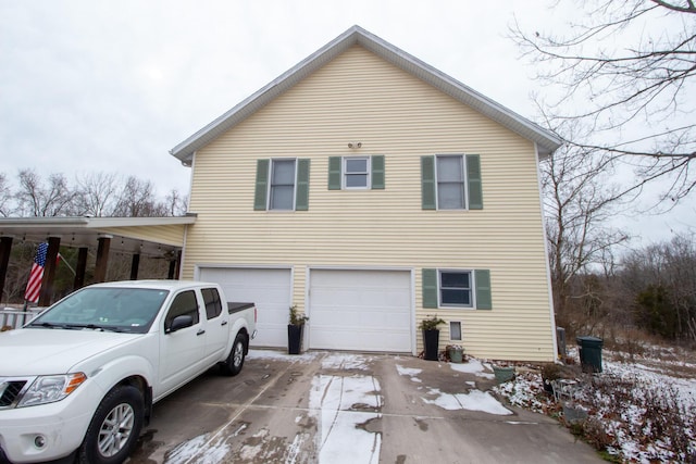 view of snowy exterior featuring a garage