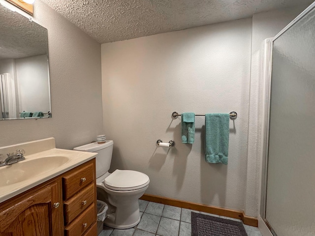 bathroom featuring tile patterned floors, toilet, a shower with shower door, a textured ceiling, and vanity