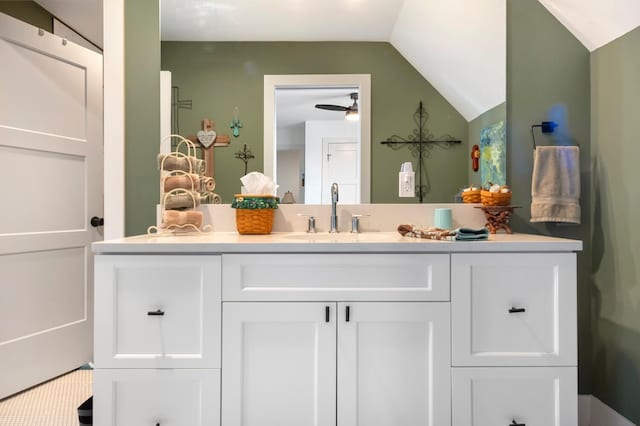 bathroom featuring vanity, ceiling fan, and vaulted ceiling