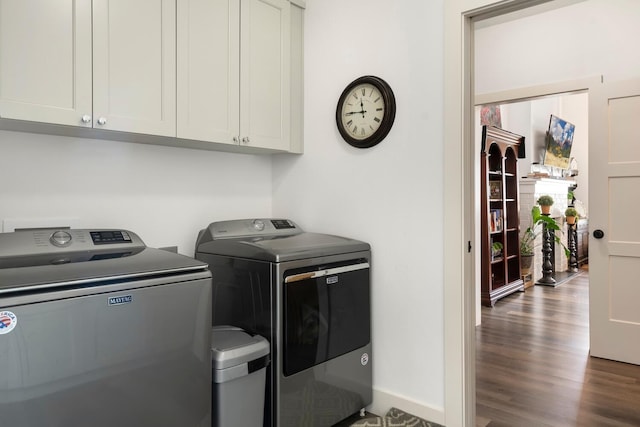 washroom featuring washing machine and clothes dryer, cabinets, and dark hardwood / wood-style floors