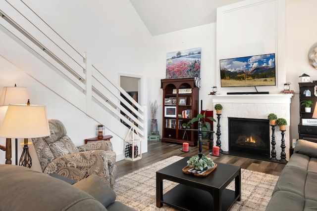 living room featuring dark hardwood / wood-style flooring, a fireplace, and high vaulted ceiling