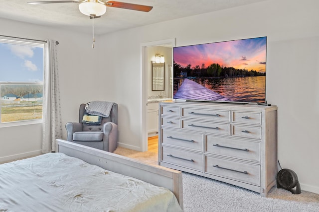 carpeted bedroom featuring ceiling fan and ensuite bath