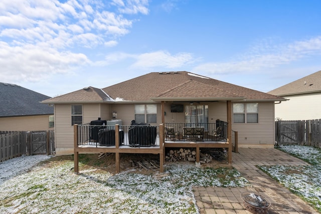 snow covered rear of property featuring a patio area