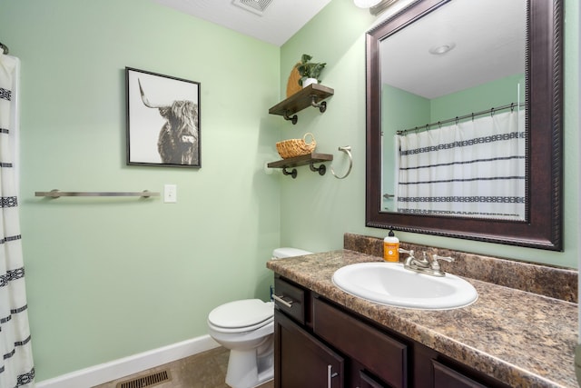 bathroom featuring tile patterned flooring, vanity, and toilet