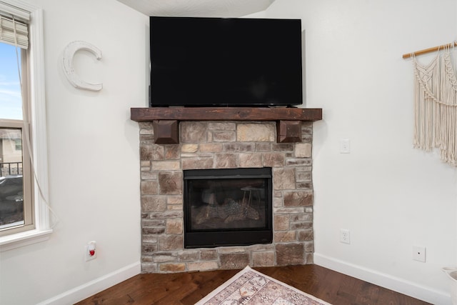 room details with hardwood / wood-style flooring and a stone fireplace