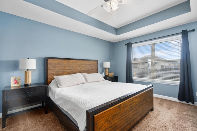 bedroom with carpet floors, a raised ceiling, and ceiling fan