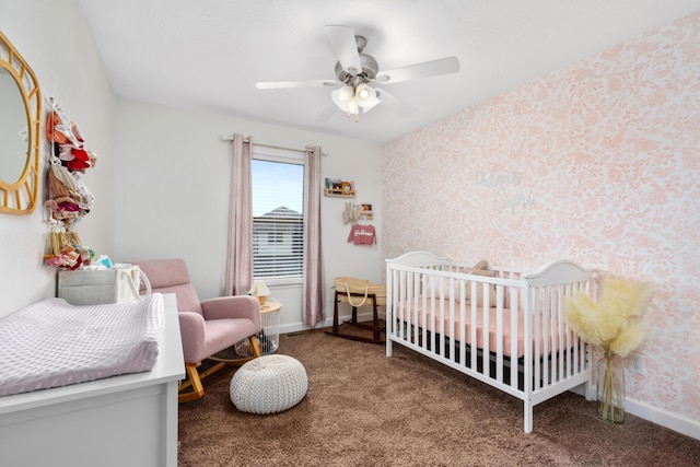 carpeted bedroom featuring ceiling fan and a nursery area