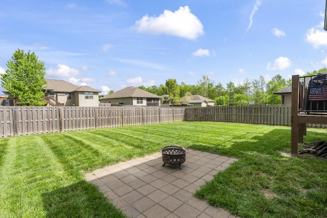 view of yard featuring a residential view, a patio area, a fenced backyard, and an outdoor fire pit