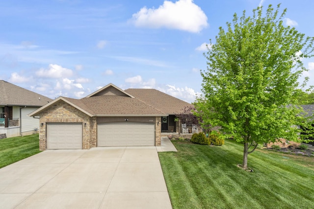 single story home featuring a front yard, a shingled roof, driveway, brick siding, and an attached garage