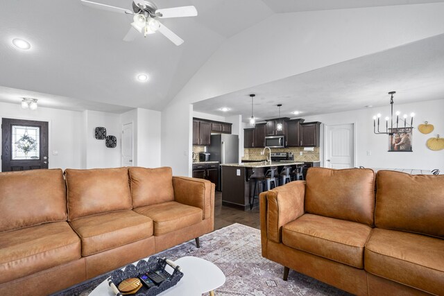 living room featuring recessed lighting, ceiling fan with notable chandelier, dark wood-style flooring, and lofted ceiling