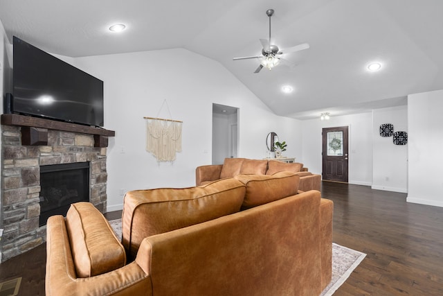 living room featuring lofted ceiling, baseboards, dark wood-style flooring, a ceiling fan, and a stone fireplace