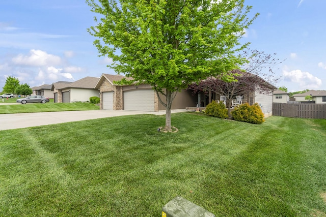 view of front of house with a front yard, driveway, a garage, and fence