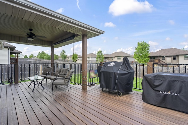wooden terrace with area for grilling, ceiling fan, and a residential view