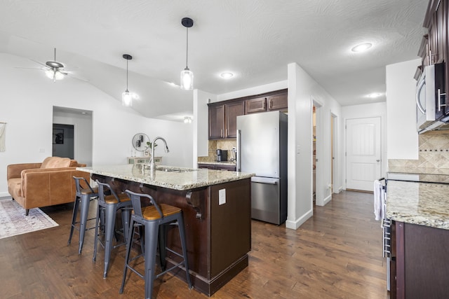 kitchen with ceiling fan, stainless steel appliances, backsplash, and a sink