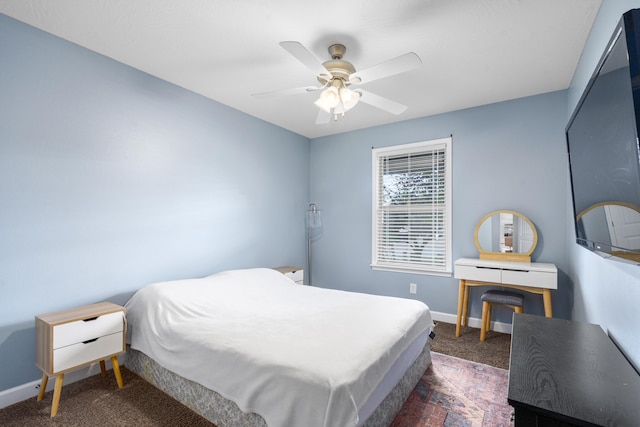 bedroom with dark colored carpet, ceiling fan, and baseboards