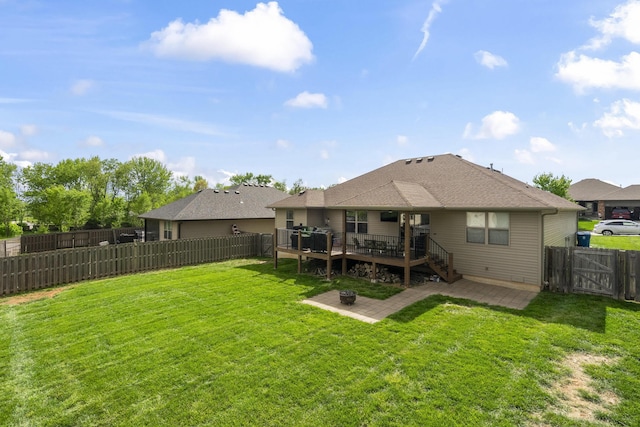 rear view of house with a patio, a wooden deck, a yard, a fenced backyard, and a gate