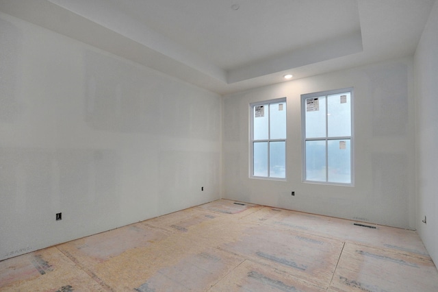 unfurnished room featuring a raised ceiling