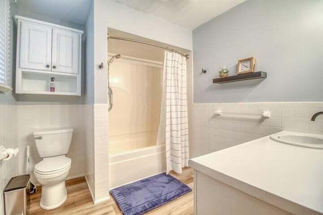 full bathroom with shower / bath combo with shower curtain, vanity, tile walls, and hardwood / wood-style flooring