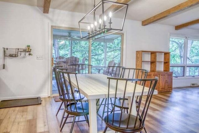 dining room with beamed ceiling, hardwood / wood-style floors, and a notable chandelier