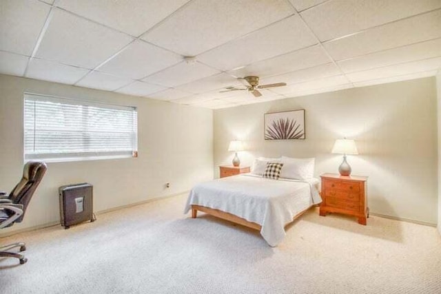 carpeted bedroom with ceiling fan and a drop ceiling