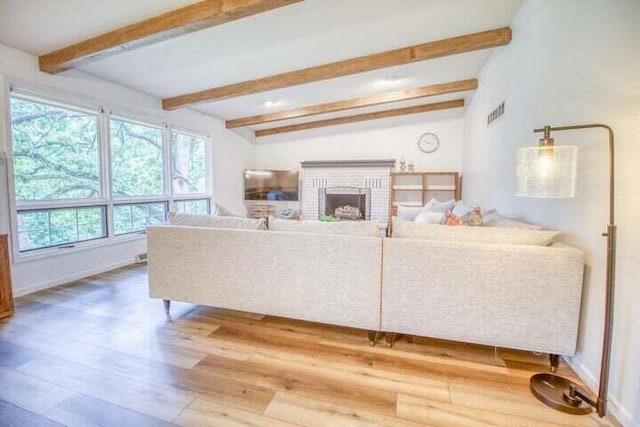 living room with a fireplace, wood-type flooring, and vaulted ceiling with beams