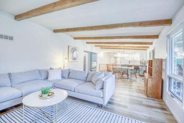 living room with light hardwood / wood-style flooring and beamed ceiling