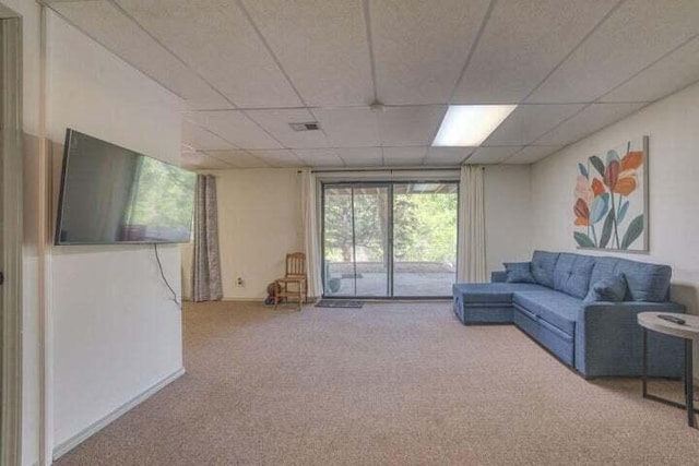 carpeted living room with a paneled ceiling