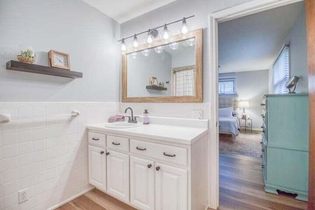 bathroom with vanity, hardwood / wood-style flooring, and tile walls