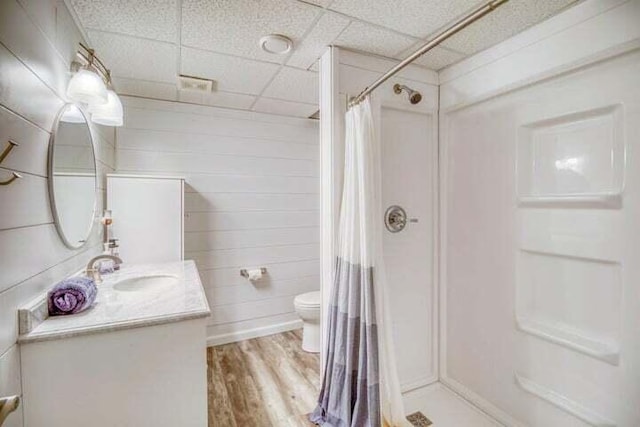 bathroom with wood-type flooring, vanity, a shower with curtain, and a paneled ceiling