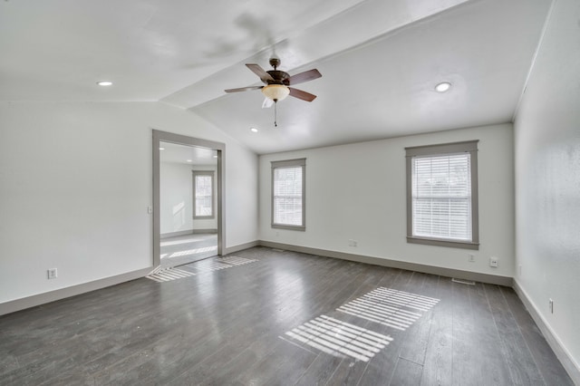 empty room featuring ceiling fan, lofted ceiling, dark wood-type flooring, and a wealth of natural light