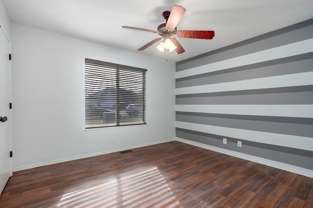 unfurnished room with ceiling fan and dark wood-type flooring